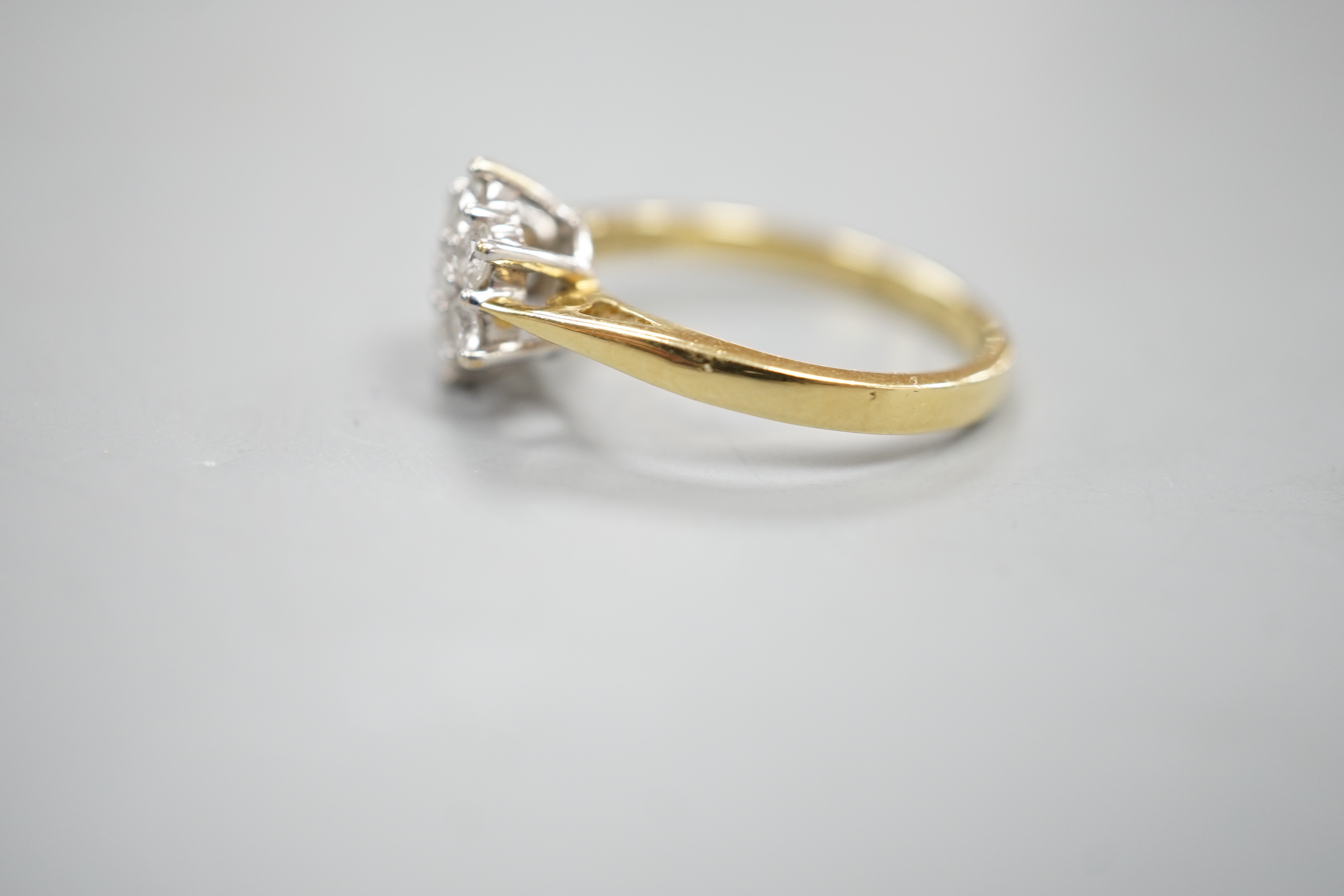 A modern 18ct gold and seven stone diamond set cluster ring, size O, gross 3.4 grams.